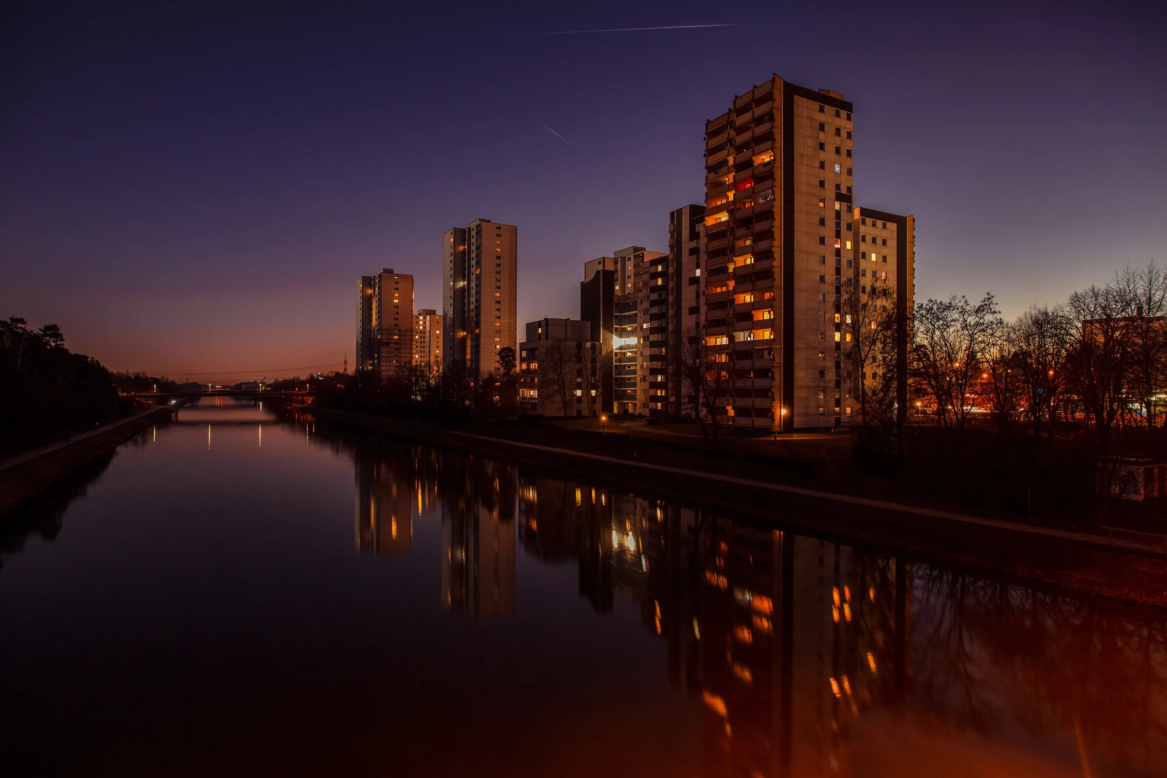 Wohngebäude an einem Kanal in der Abenddämmerung